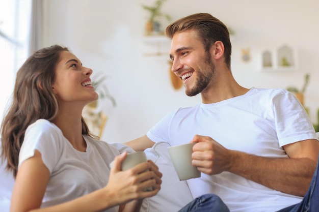 Joyeux jeune couple le matin à la maison dans le salon