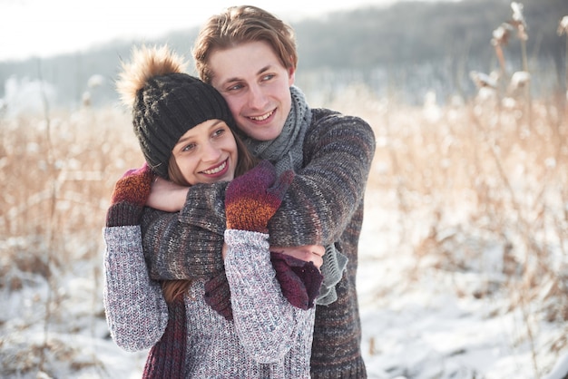 Joyeux jeune couple s'amuser dans le parc d'hiver