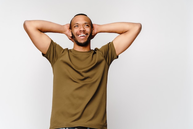 Joyeux jeune homme amical dans un t-shirt vert sur fond gris clair