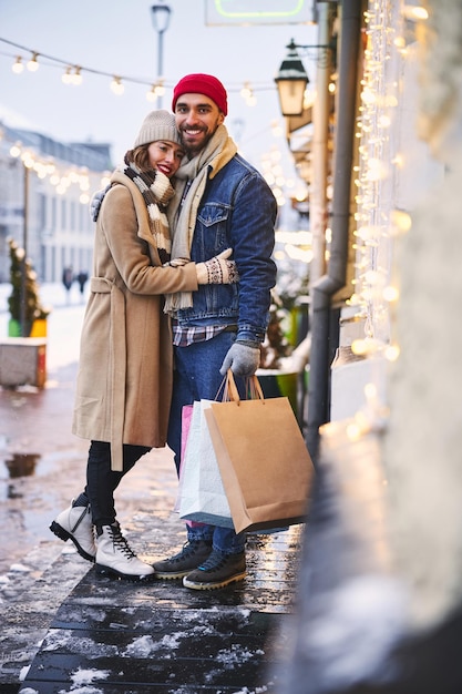 Joyeux jeune homme datant avec sa petite amie dans la ville d'hiver