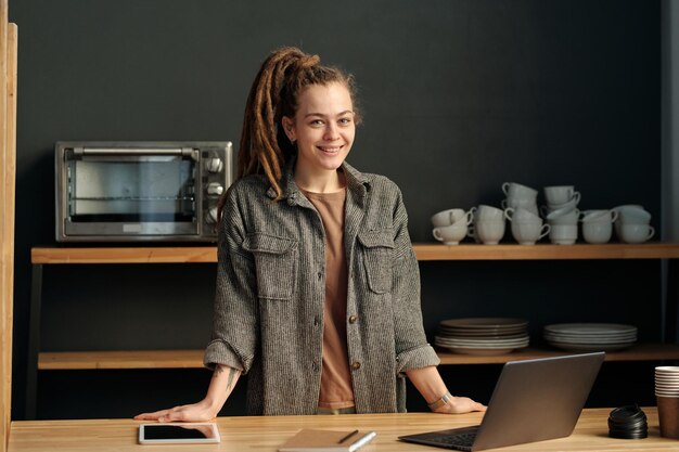 Joyeux jeune propriétaire d'un café moderne