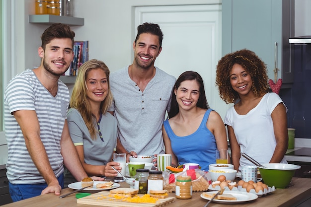 Joyeux jeunes amis debout à la table