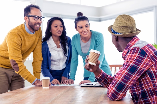 Joyeux jeunes gens d&#39;affaires discutant entre eux au bureau de la création