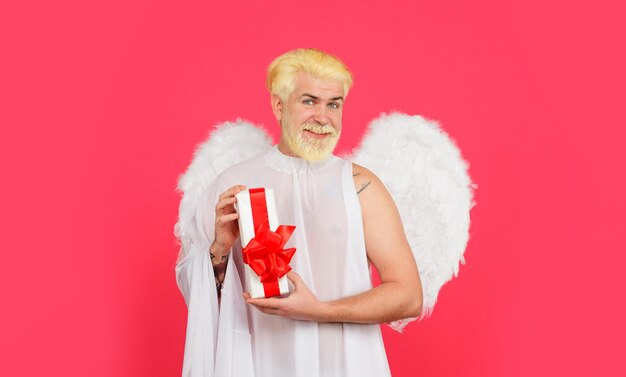 Photo joyeux jour de la saint-valentin février jour de la saint-valentin ange dans les ailes blanches avec valentin présent souriant