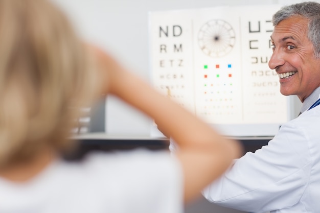 Photo joyeux médecin faisant un test oculaire sur un patient dans un hôpital