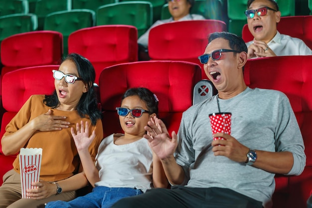 De joyeux moments en famille asiatique au cinéma, partageant joie et convivialité tout en regardant un film