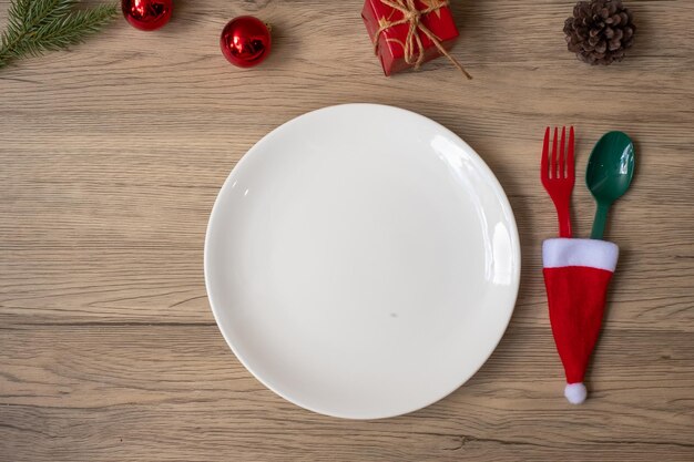 Joyeux Noël avec assiette fourchette et cuillère sur fond de table en bois Fête de Noël et concept de bonne année