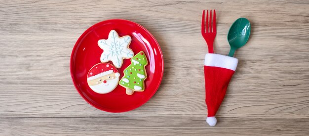 Joyeux Noël avec des biscuits faits maison, une fourchette et une cuillère sur fond de table en bois. Concept de Noël, fête et bonne année
