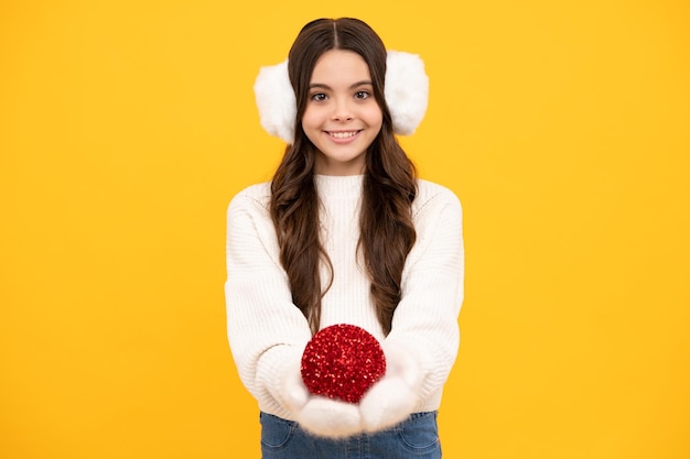 Joyeux noël et bonne année enfant en vêtements d'hiver adolescente avec boule de noël décorative