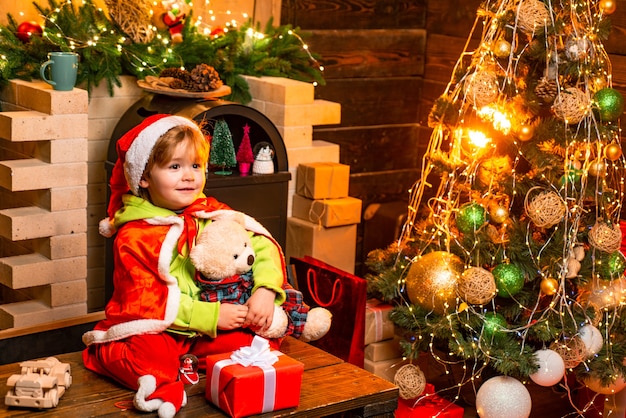 Joyeux Noel et bonne année. Kid profiter des vacances d'hiver à la maison. Fête de la famille Noël. Maison remplie de joie et d'amour. Mignon petit garçon enfant jouer près de l'arbre de Noël. Cadeaux et surprises.