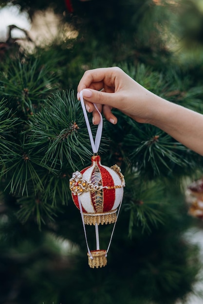 Joyeux Noël et bonne année Les mains des femmes décorent le sapin de Noël avec des boules et des jouets