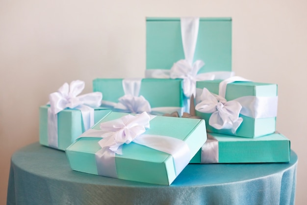 Joyeux Noël et bonne année! Tôt le matin. Des boîtes bleues avec des cadeaux avec des rubans blancs se dressent sur la table.