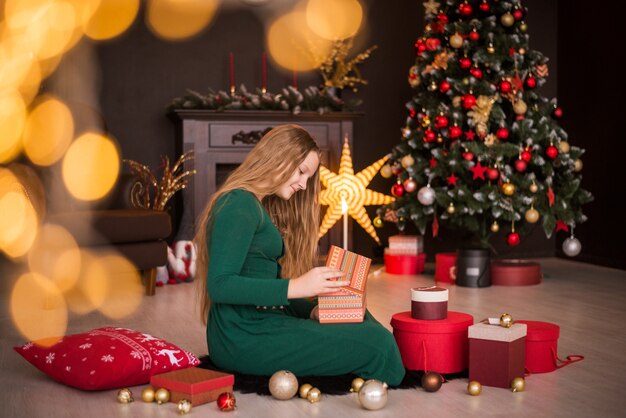 Joyeux Noël et bonnes fêtes. Joyeuse jolie adolescente ouvrant des cadeaux.