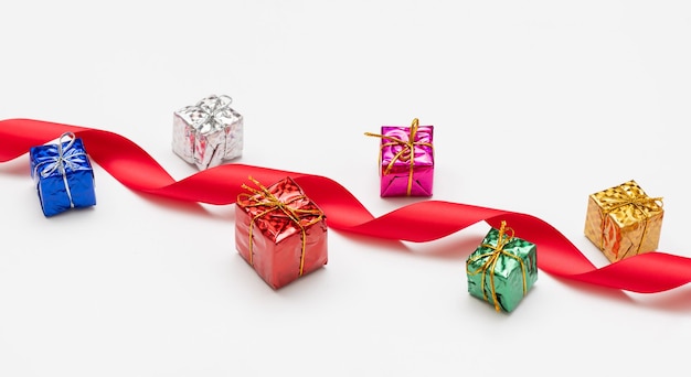 Joyeux Noël carte faite de branches de sapin coffrets cadeaux décoration rouge scintille et confettis sur fond blanc