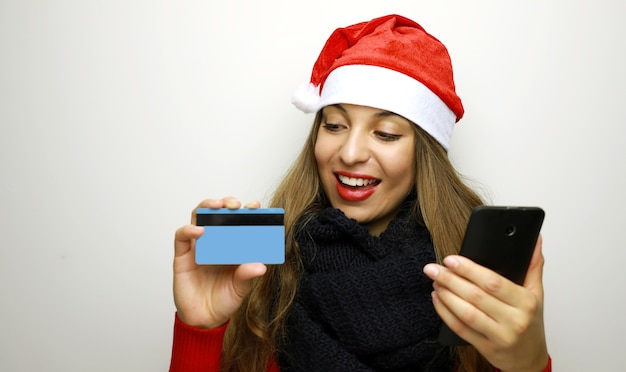 Joyeux Noël femme faisant du shopping avec carte de crédit et téléphone mobile