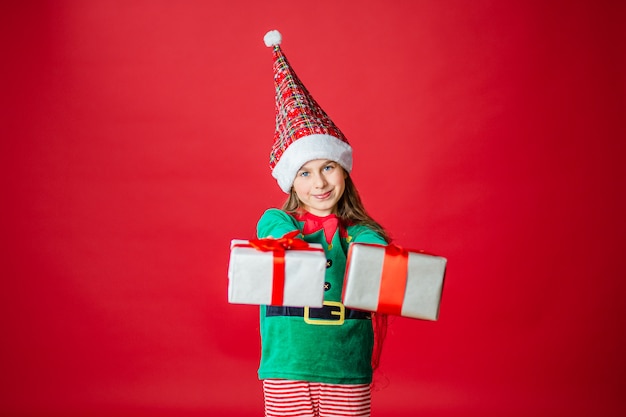 Joyeux Noël, heureuse jolie fille avec des cadeaux dans un costume d'elfe d'assistance du père Noël