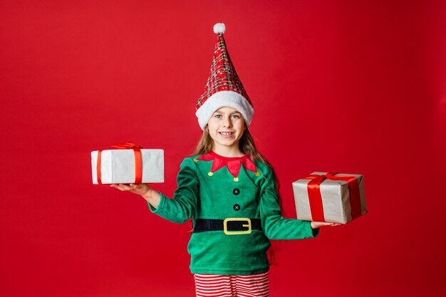 Joyeux Noël, heureuse jolie fille avec des cadeaux dans un costume d'elfe d'assistance du père Noël