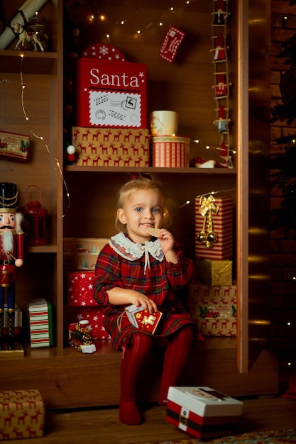 Photo joyeux noël et joyeuses vacances une petite fille dans une robe à carreaux