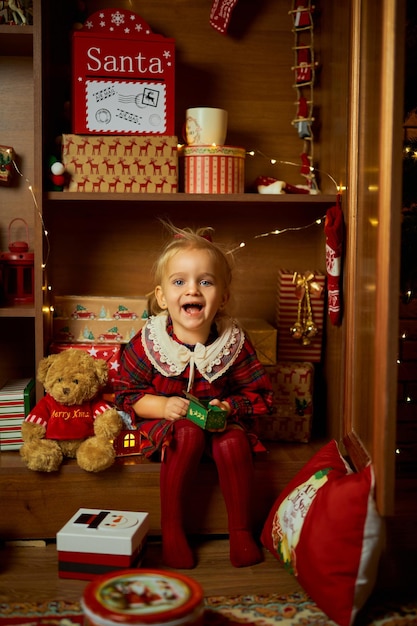 Photo joyeux noël et joyeuses vacances une petite fille dans une robe à carreaux