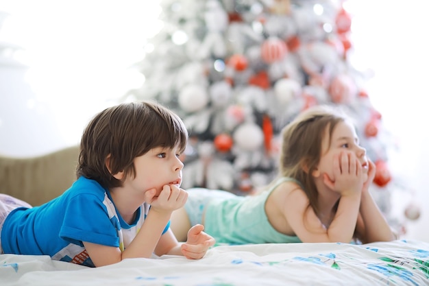 Joyeux Noël lumineux. Beau bébé profite de Noël. Souvenirs d'enfance. Santa girl petit enfant fête Noël à la maison. Vacances en famille. Fille enfant mignon humeur joyeuse jouer près de l'arbre de Noël.