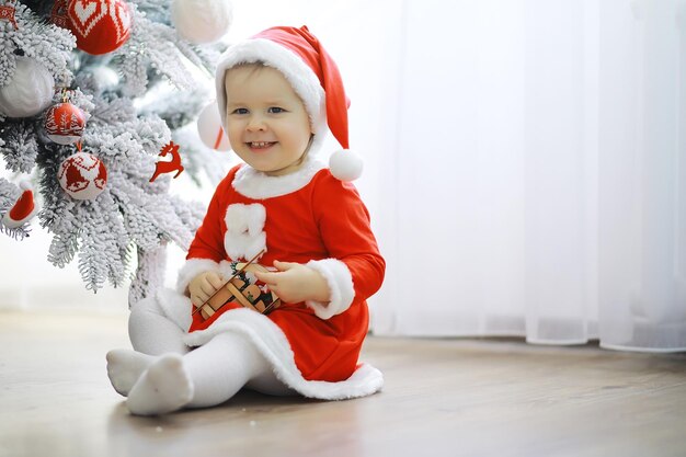 Joyeux Noël lumineux Joli bébé profite de Noël Souvenirs d'enfance Père Noël petit enfant célèbre Noël à la maison Vacances en famille Fille mignonne enfant humeur joyeuse jouer près de l'arbre de Noël