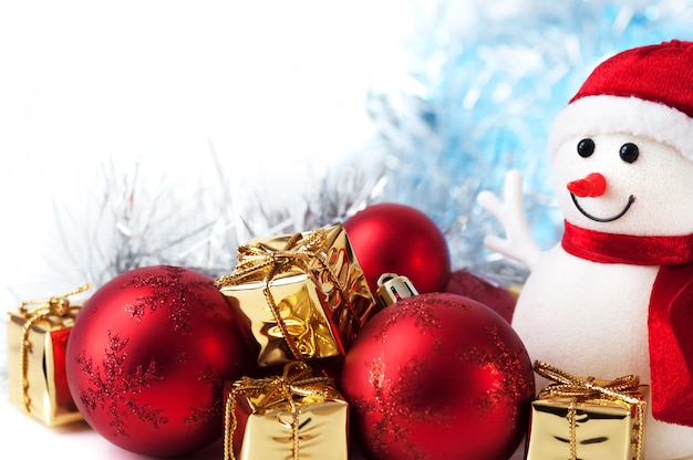 Joyeux Noël, Nouvel An, bonhomme de neige, cadeaux dans des boîtes en or et des boules rouges