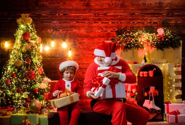 Joyeux noël souriant petit enfant garçon en costume de père Noël avec la famille du père noël joyeuses fêtes