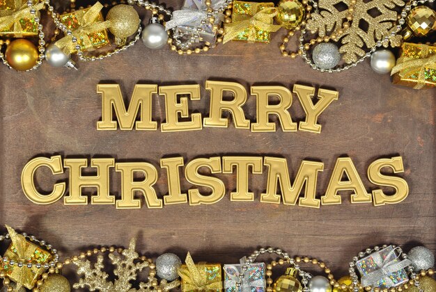 Joyeux Noël texte d'or et décorations de Noël sur un fond en bois