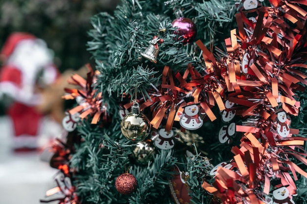 Joyeux NoëlGros plan d'une boîte de cadeaux de boules colorées et d'une image de voeux de Noël décoration de colisbell sur fond d'arbre de Noël vert Décoration pendant Noël et le Nouvel An