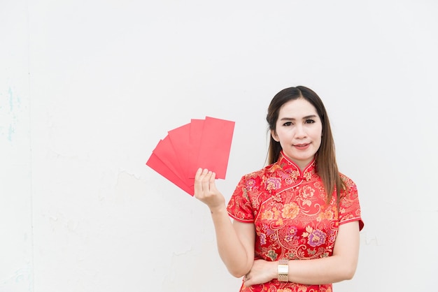 joyeux Nouvel An chinois. Le portrait de la femme asiatique a l'enveloppe rouge avec le beau sourire