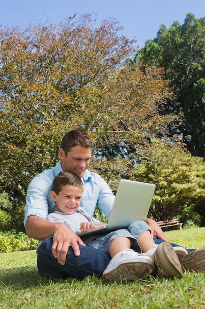 Joyeux papa et fils avec un ordinateur portable
