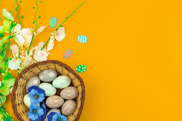 Joyeux Pâques avec décoration de nids avec des œufs colorés et des fleurs printanières, photo de concept de carte de voeux