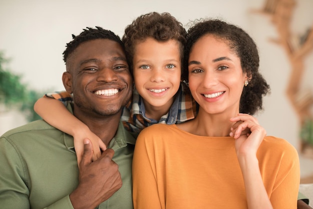 Joyeux parents divers et fils enfant s'embrassant à la maison