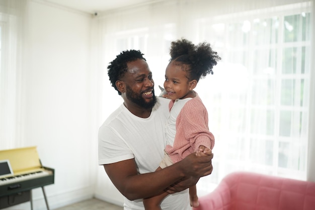 Joyeux père et fille de famille multiethnique et leurs loisirs à la maison