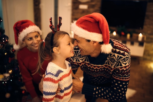 Photo joyeux père et fille s'amusant le soir de noël à la maison