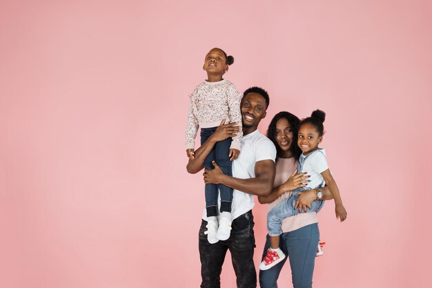 Photo joyeux père et maman portant leurs filles sur les mains