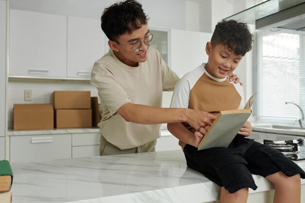 Joyeux père montrant à son fils un nouveau livre d'histoires