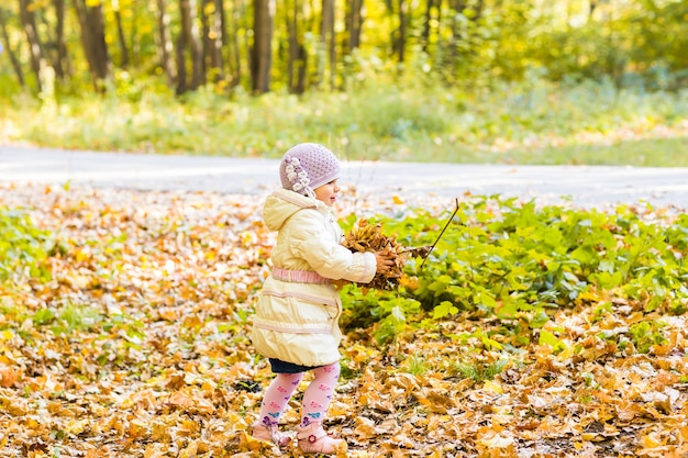Joyeux petit enfant, petite fille riant et jouant à l'automne sur la promenade dans la nature à l'extérieur