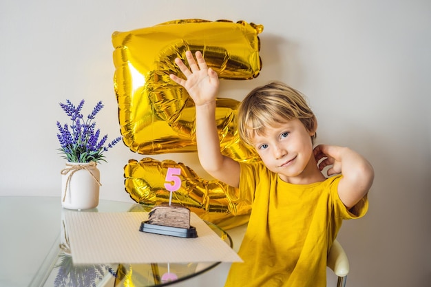 Joyeux petit garçon célébrant son anniversaire et soufflant des bougies sur un gâteau fait maison à l'intérieur Fête d'anniversaire pour les enfants Insouciant bonheur d'anniversaire d'enfance