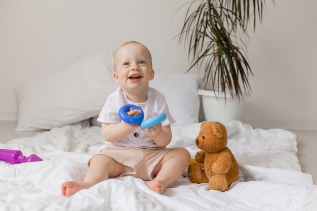 Joyeux petit garçon jouant avec des jouets sur une couverture, ours en peluche, santé, bannière, carte