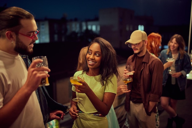 Joyeux positifs heureux jeunes amis se réunissant à l'extérieur dans un café s'amusant et buvant des cocktails Concept de fête loisirs amusants et joie week-ends célébration culture de la jeunesse