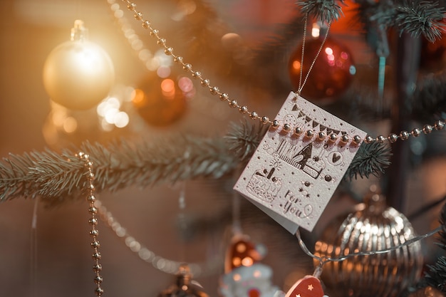 Joyeux x-mas, gros plan de boules colorées, boîte de cadeaux et décoration de colis photo de voeux de Noël sur fond d'arbre de Noël vert Décoration pendant Noël et nouvel an.
