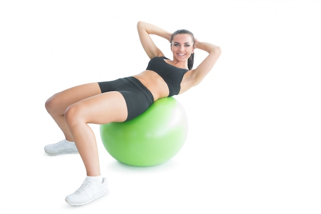 Joyful fit femme faire un exercice sur un ballon d&#39;exercice