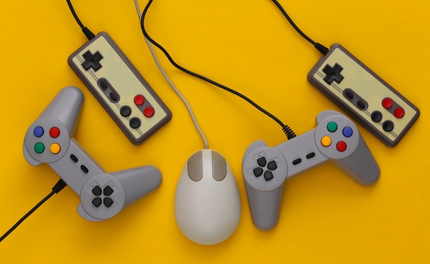 Joysticks rétro et souris pc sur fond jaune. Jeux rétro, appareils de jeux, gadgets