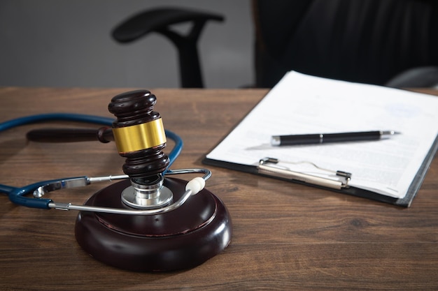 Juge marteau documents et stéthoscope sur la table en bois