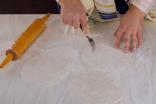 Les Juifs orthodoxes roulent de la pâte pour Matzos pour la Pâque à mettre au four pour le jour de la fête juive