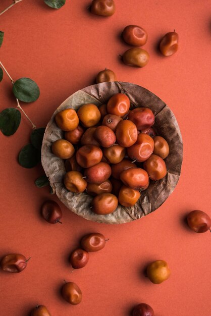 Jujube indien ou ber ou berry ou Ziziphus mauritiana, dans un bol ou sur fond blanc