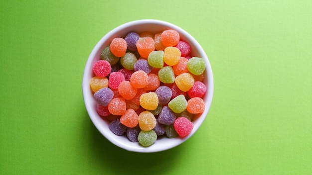 Jujubes colorés sur table verte, vue du dessus.