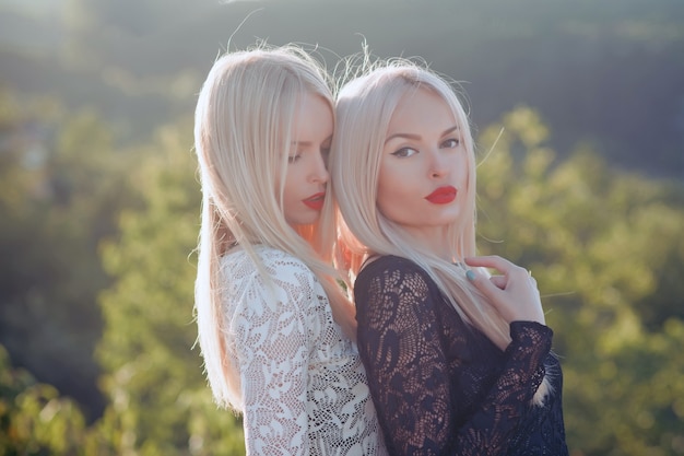 Jumelles de soeurs posant sur le paysage naturel ensoleillé