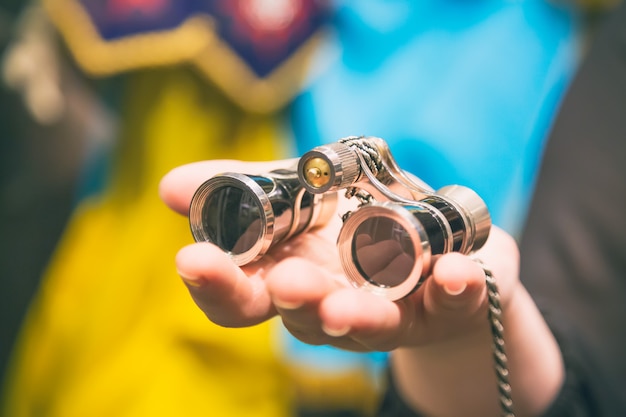 Jumelles Vintage à la main féminine dans le théâtre ou l'opéra